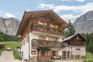 a house in the mountains with flowers on the balcony at Chalet Crepes De Sela in Canazei