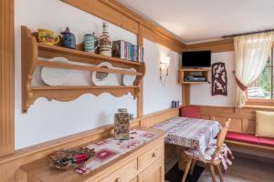 a kitchen with a table and a small table and chair at Chalet Crepes De Sela in Canazei