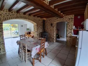 a kitchen with a table and chairs in a room at Gîte De La Haie Bourgère in Moulay