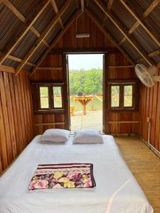 a bedroom with a large bed in a wooden house at Bonomali Mangrove Resort in Dhāngmāri Forest Office
