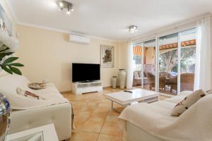 a living room with white furniture and a flat screen tv at Villa Private Pool Los Cristianos in Los Cristianos