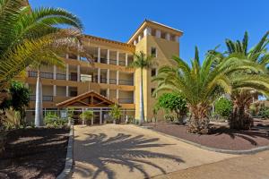 a building with palm trees in front of it at Villa Private Pool Los Cristianos in Los Cristianos