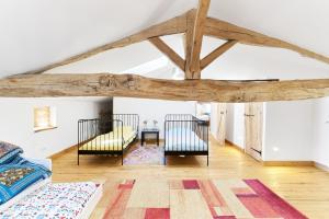 a room with two beds and a wooden ceiling at Gite La Ferme En Sud Charente in Montboyer