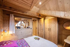 a bedroom with a bed in a wooden cabin at L'alpin in Les Déserts
