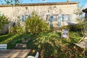 a house with a table and chairs in the yard at Gite La Ferme En Sud Charente in Montboyer