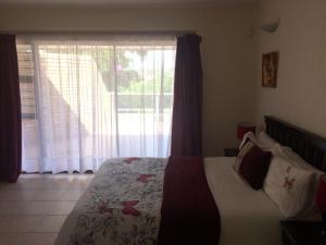 a bedroom with a bed and a large window at Buffalo View Lodge in East London