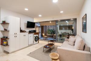 a living room with a couch and a kitchen at The Apex Boutique Studio in Athens