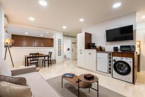 a living room with a couch and a washer and dryer at The Apex Boutique Studio in Athens
