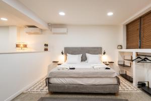 a bedroom with a large bed with white walls at The Apex Boutique Studio in Athens