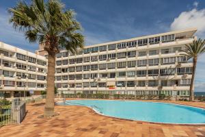 a hotel with a palm tree and a swimming pool at Apartamento Soraya in San Bartolomé