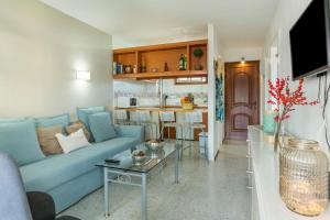a living room with a blue couch and a table at Apartamento Soraya in San Bartolomé