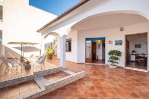an indoor patio with chairs and a table with an umbrella at By The Sea – Le Chele in Torre Lapillo