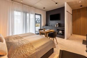 a bedroom with a bed and a table and a television at Apartment Schlossterrassen 4a in Pouch
