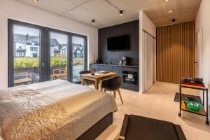a bedroom with a bed and a desk and a television at Apartment Schlossterrassen 4a in Pouch