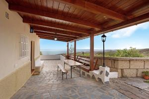 a patio with a bench and a table with a view at Finca Lucrecia in Fasnia