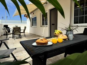 a black table with a plate of food and orange juice at Chalet Mar Y Montaña in Los Silos