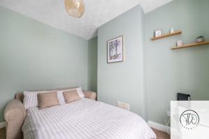 a bedroom with a bed with a striped blanket at Shamrock House in Ipswich +24 photos