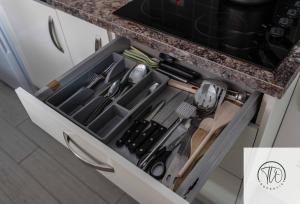 a drawer in a cabinet filled with cooking utensils at Shamrock House in Ipswich