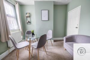 a living room with a glass table and chairs at Shamrock House in Ipswich