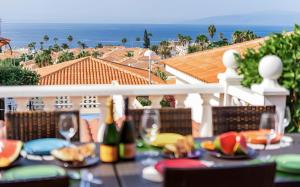 a table with food and wine glasses on a balcony at Ocean View 3bedroom Villa with pool in Callao Salvaje