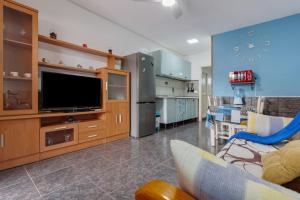 a living room with a tv and a kitchen at Casa Lita in Antigua