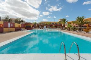 a pool at a resort with palm trees and buildings at Casa Lita in Antigua
