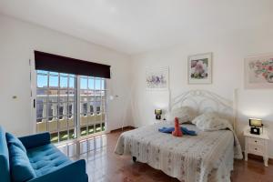 a bedroom with a bed and a blue couch at Casa del Pescador 2 in Santa Cruz de Tenerife