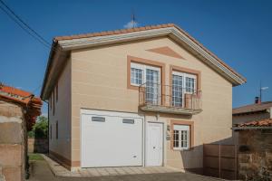 a small house with a white garage at San Pelayo in San Millán de Lara