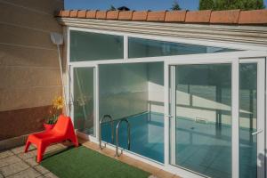 a balcony with a red chair and a swimming pool at San Pelayo in San Millán de Lara