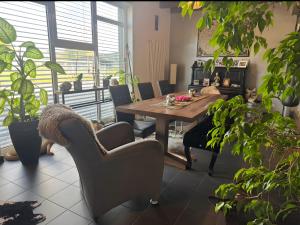 a dining room with a table and chairs and plants at Deluxe Loft Hegau Bodensee in Hilzingen