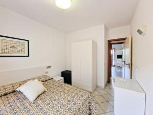 a white bedroom with a bed and a bathroom at Altaluna Apartment with Pool in Nisporto