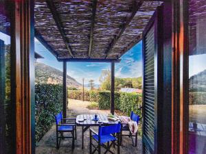 a dining room with a table and chairs and a window at Altaluna Apartment with Pool in Nisporto