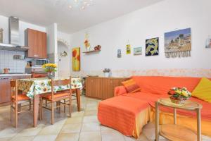 a living room and kitchen with a couch and a table at Appartamento Orchidea in Capoliveri