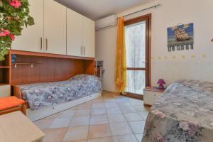 a bedroom with two beds and a window at Appartamento Orchidea in Capoliveri