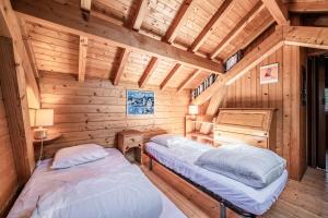 a room with two beds in a log cabin at Chalet 6p Classique - Amarock in Verchaix