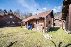 a wooden house with a yard next to a building at Chalet 6p Classique - Amarock in Verchaix
