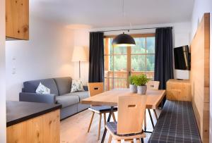 a living room with a table and a couch at Altmessnerhof in Dobbiaco
