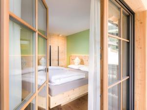 a bedroom with two beds and glass walls at Altmessnerhof in Dobbiaco