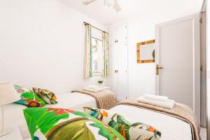 two beds in a room with white walls at Apartamento Dos Geckos in Son Parc +19 photos