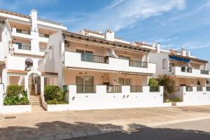 an apartment building with white walls and balconies at Apartamento Dos Geckos in Son Parc