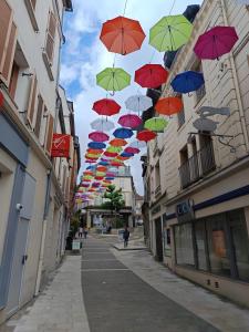a bunch of colorful umbrellas hanging over a street at Logement Cosy centre Joigny C4 in Joigny