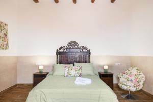 a bedroom with a large bed with two chairs at Casa Abuela Nicolasa in Máguez