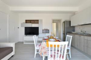 a kitchen and dining room with a table and chairs at Venere cala gonone vista mare in Cala Gonone