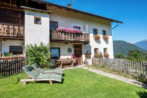 a house with two chairs and a table in a yard at Urthalerhof Historic in Valdaora