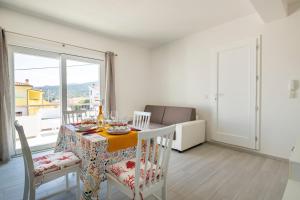 a dining room with a table and chairs and a window at Venere cala gonone vista mare in Cala Gonone +7 photos