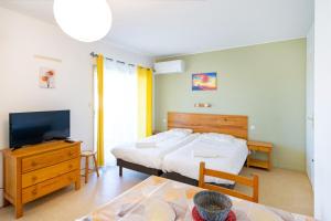 a bedroom with a bed and a tv and a table at Les Mimosas - Appartement 10 in Cazaubon