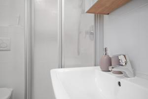 a white bathroom with a sink and a shower at Rafaser - Apartment Albina in Feldthurns +7 photos