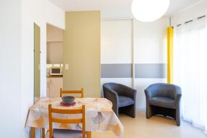 a dining room with a table and two chairs at Les Mimosas - Appartement 10 in Cazaubon
