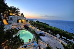 an aerial view of a house with a swimming pool and the ocean at Tenuta Belvedere Luxury e Spa in Gagliano del Capo