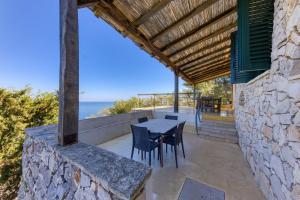an outdoor patio with a table and chairs and the ocean at Tenuta Belvedere Luxury e Spa in Gagliano del Capo